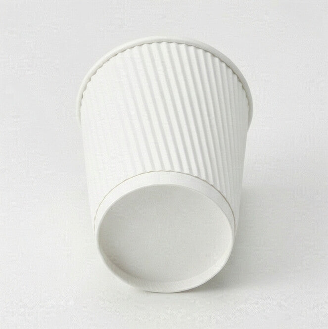 12oz white ripple wall paper cup tilted to show the base ring from low angle, white ripple exterior on light grey