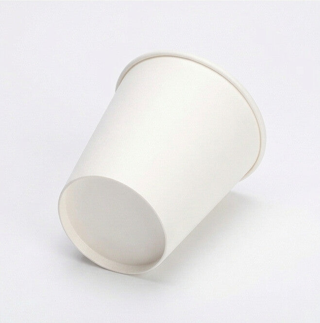 White single wall paper cup tipped on its side on a light grey background, exposing the flat base circle and interior