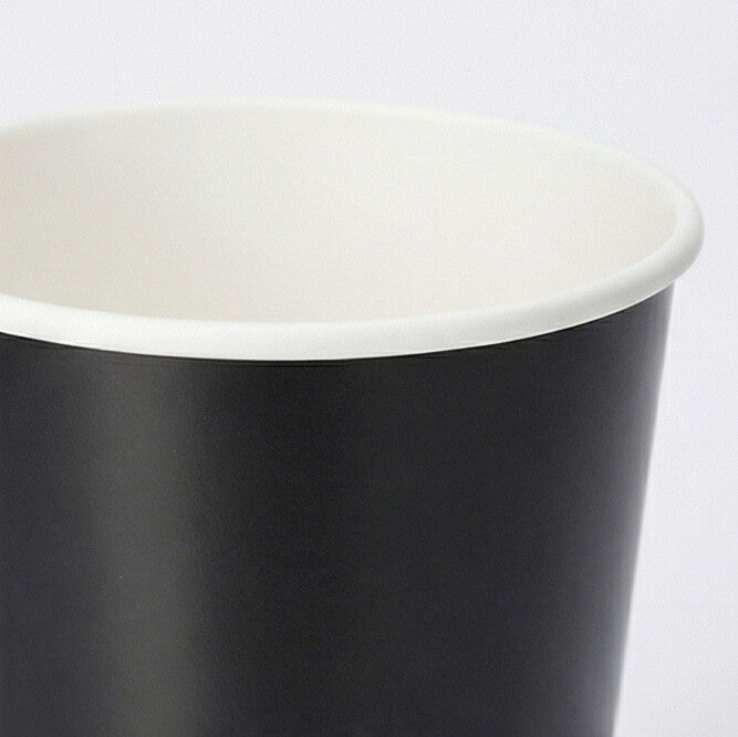 Close-up of the white rolled rim and interior of a 16oz black double wall paper cup from above on a light grey background