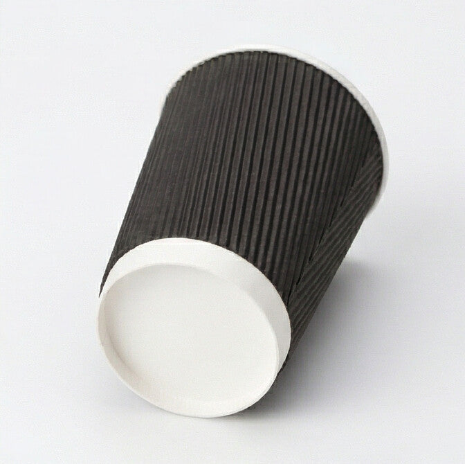 16oz black ripple wall paper cup tilted to show the white base band and base circle, black ripple exterior on light grey