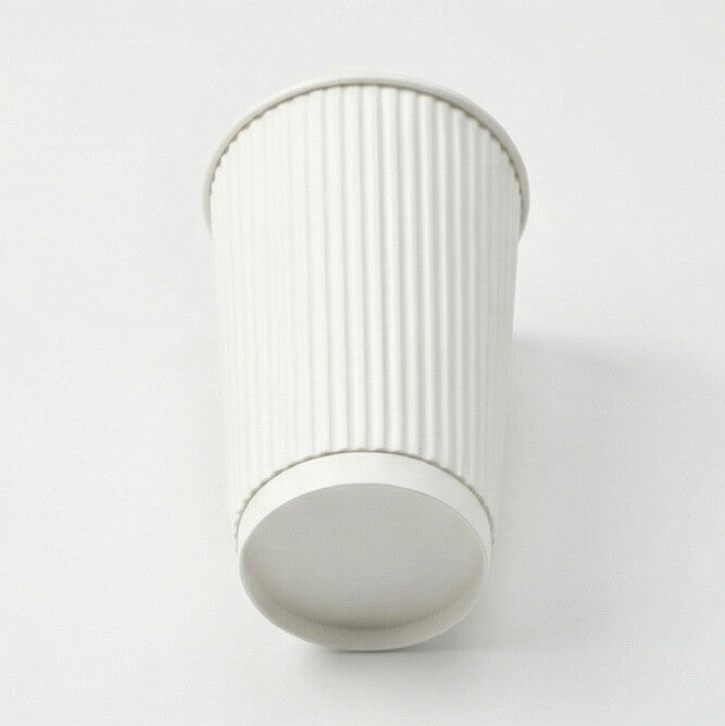 16oz white ripple wall paper cup tilted to show the base ring from low angle, ripple exterior on light grey