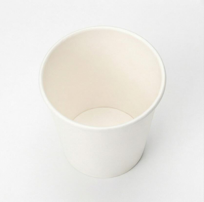 Overhead shot looking directly down into a white single wall paper cup, showing the circular rim and interior on white