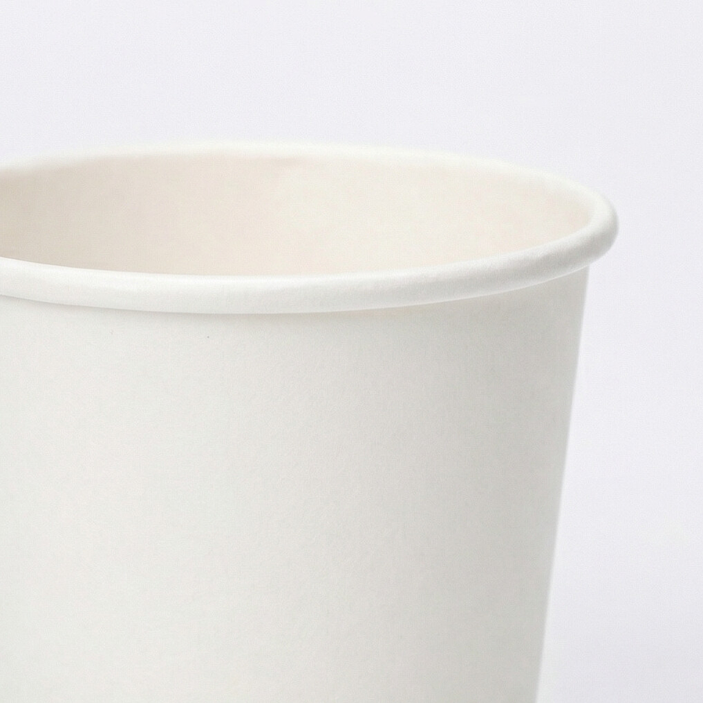 Extreme close-up of the rolled rim and interior of a white 6oz paper cup, showing paper texture and upper sidewall detail