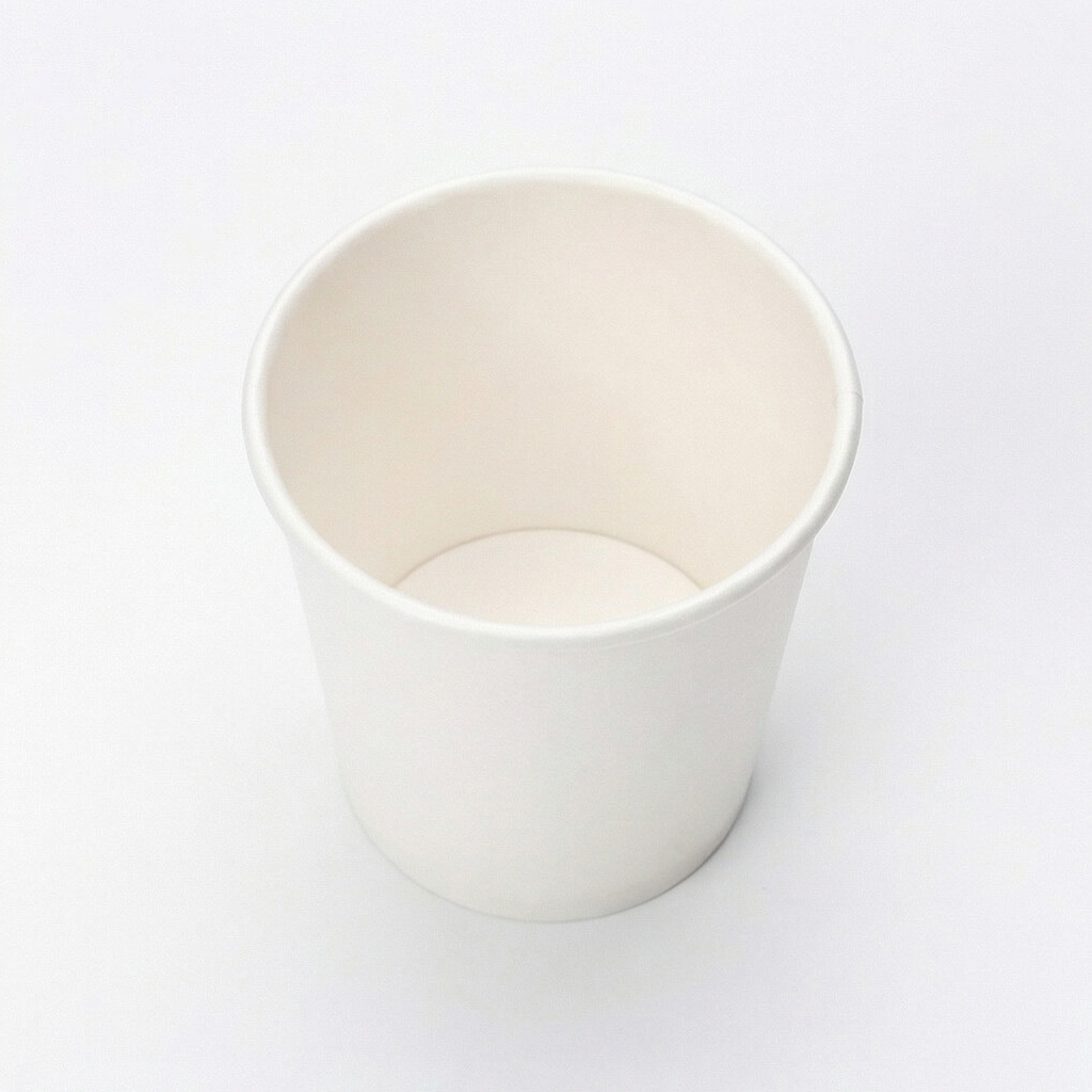 Overhead shot looking directly down into an empty white paper cup, showing the clean circular interior on white