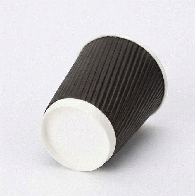 8oz black ripple wall paper cup tilted to show the white base band and base circle, black ripple exterior on light grey