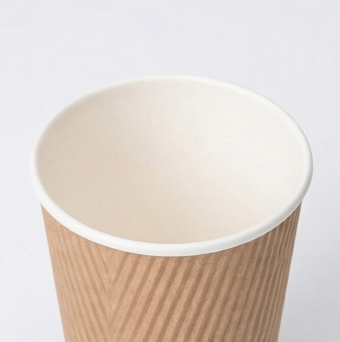 Close-up from above of the white rim and cream interior of an 8oz kraft ripple wall paper cup on light grey