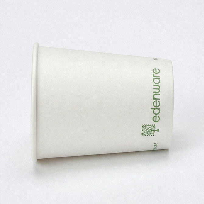 8oz white compostable single wall paper cup leaning at steep angle showing smooth white side and base, light grey