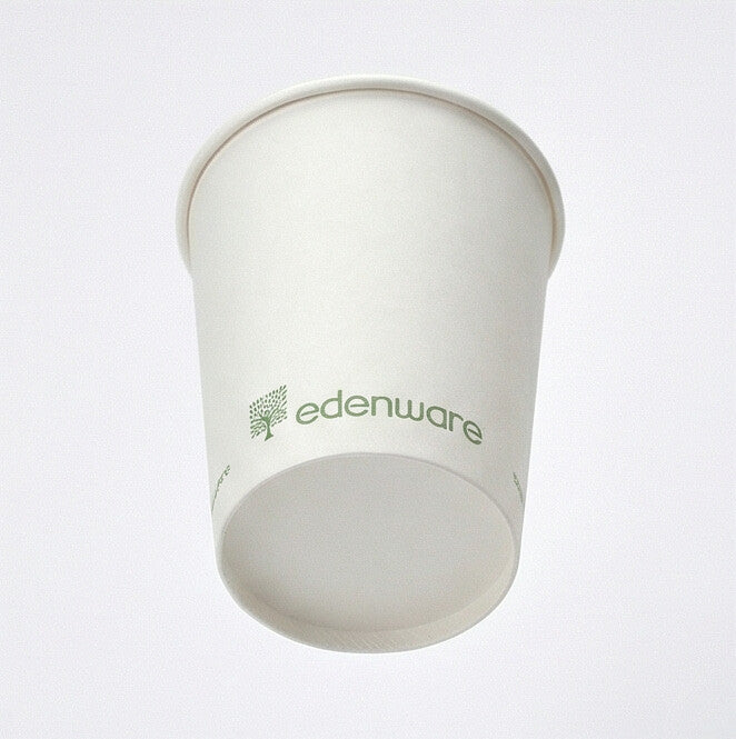 8oz white compostable single wall paper cup tilted back showing base ring from low angle, green printed exterior, light grey