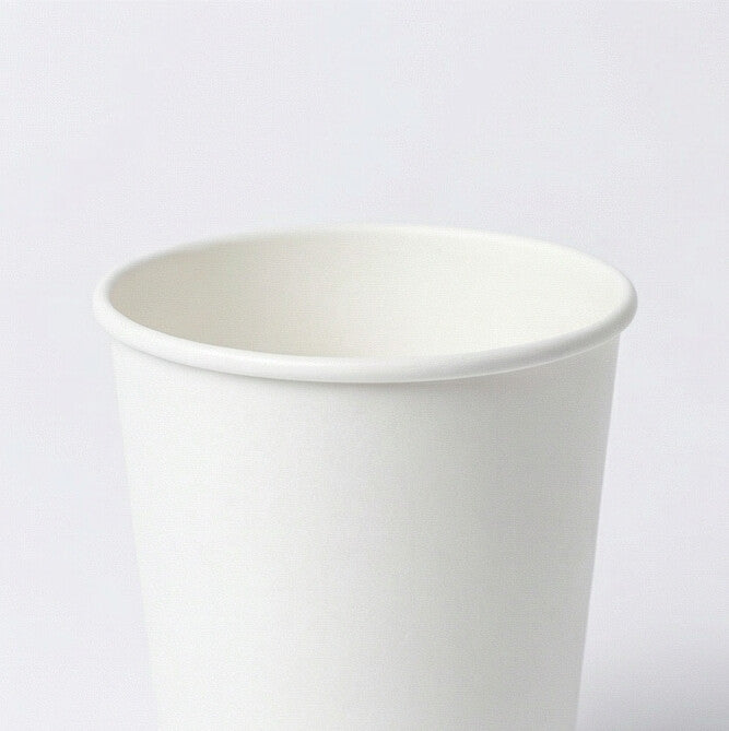 Close-up from above of the white rolled rim and open interior of an 8oz double wall paper cup, light grey background