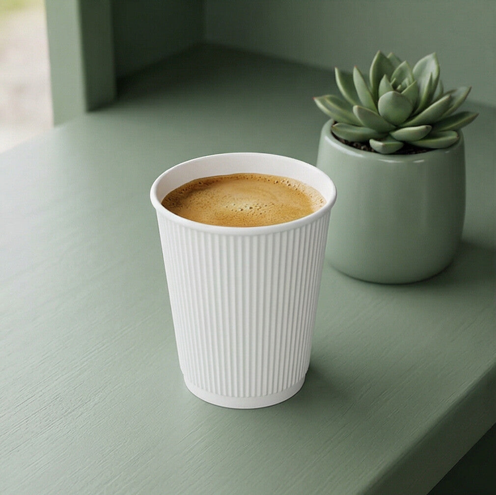 8oz White Ripple Wall Paper Cup filled with frothy coffee on sage green counter, small succulent plant beside