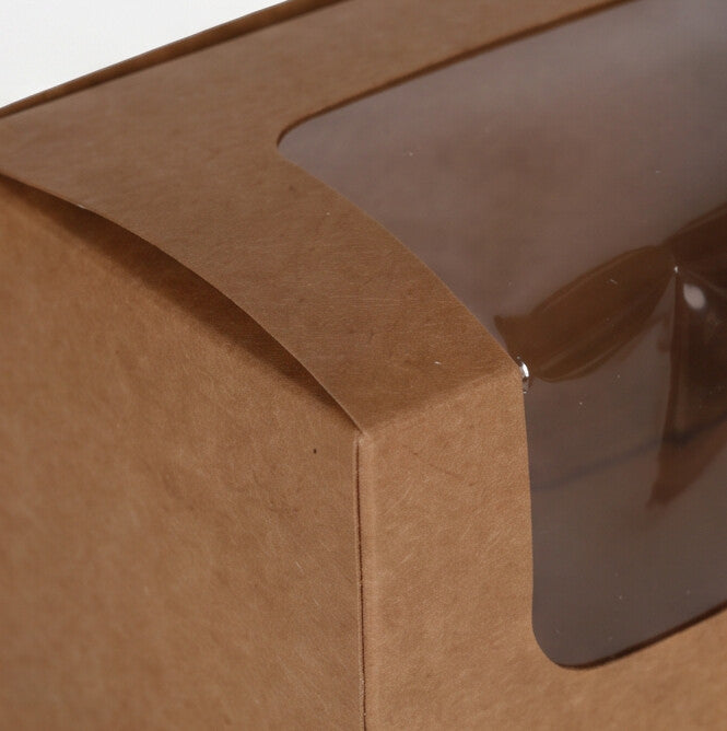Kraft bloomer sandwich box, close-up corner detail of curved lid edge and clear plastic display window showing natural kraft brown board construction quality on white background
