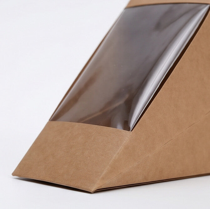 Kraft sandwich wedge deep fill box, close-up overhead angle view showing large clear plastic display window and deep interior of natural kraft brown construction on white background