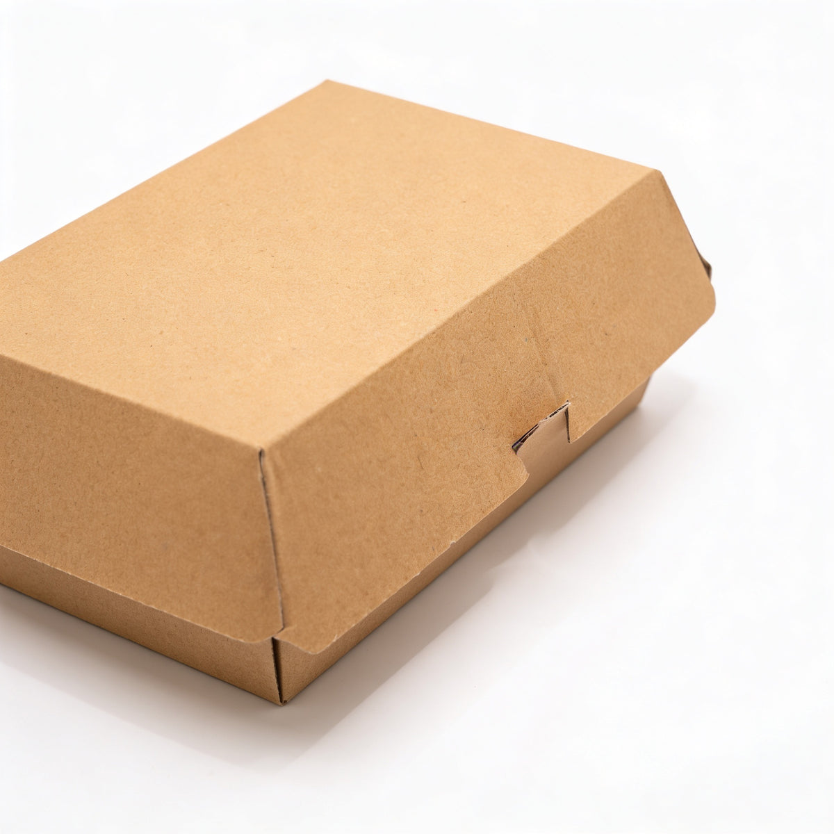 Large corrugated burger box closed, three-quarter angle view showing natural kraft brown corrugated construction and locking tab closure on white background