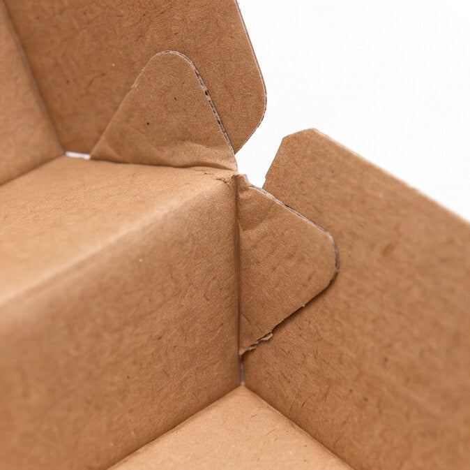 Large corrugated burger box open, close-up interior corner view showing kraft corrugated board construction detail and folded side panels