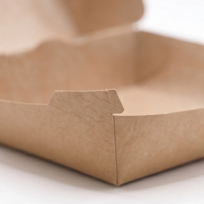 Large kraft burger box open, close-up corner view showing natural kraft paper construction detail and folded base panel on white background