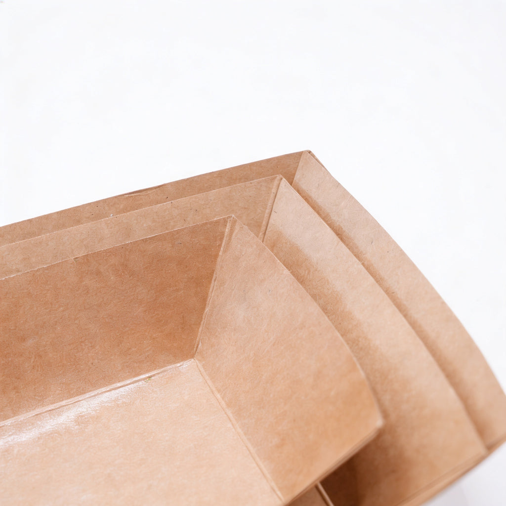 Medium kraft paper boat trays stacked, three-quarter angle view showing multiple nested trays and natural kraft brown construction on white background