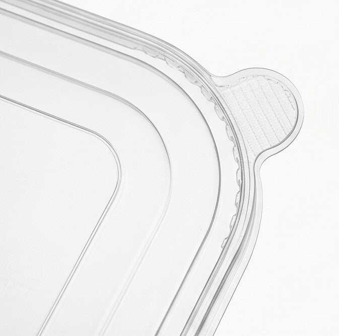 Close-up detail of the textured pull tab and ribbed snap-fit rim corner of a clear PET rectangular lid.