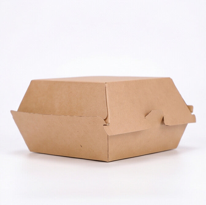 Small corrugated burger box closed, three-quarter angle view showing natural kraft brown corrugated construction and locking tab closure on white background