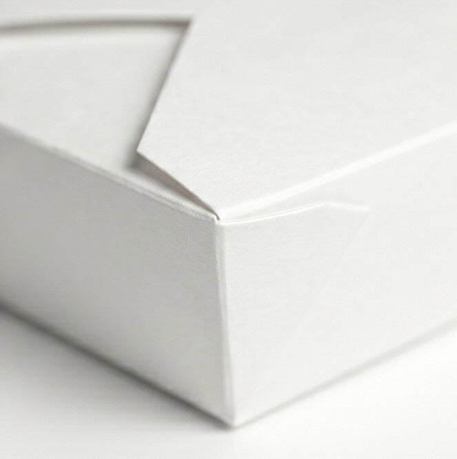 Close-up detail of white paper takeaway food container No. 5 closed, showing fold-over flap, tuck-in tab and corner construction