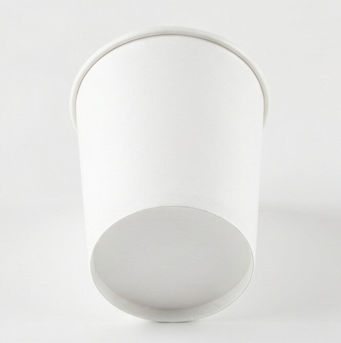 White paper soup container 16oz viewed from a low angle, emphasizing the tapered body, base and rolled rim.